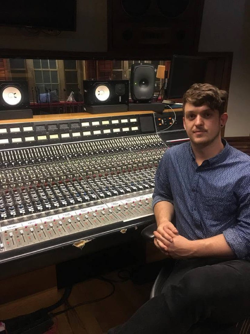 Adam Whybro seated beside the Neve mixing console at Roundhead Studios during his internship there